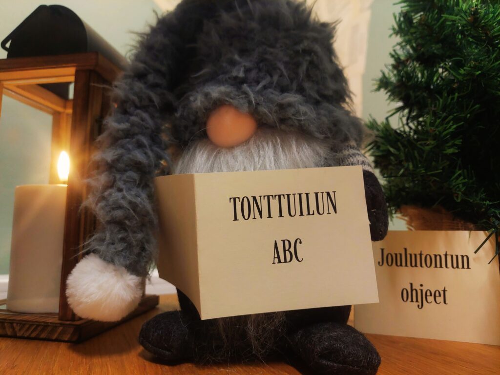 Harmaamyssyinen tonttu lukee Tonttuilun ABC -kirjaa